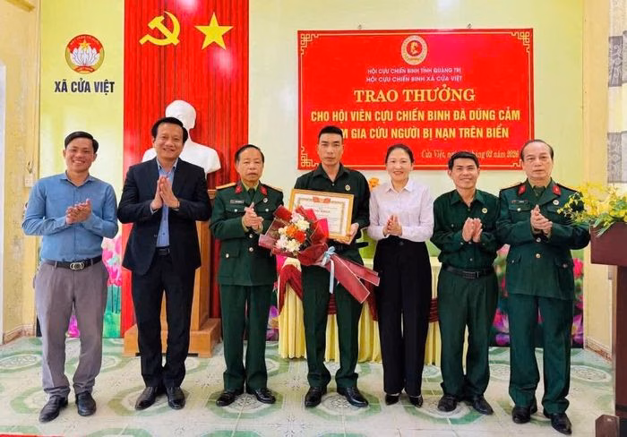 Cựu chiến binh Bùi Văn Linh (người đứng giữa) nhận bằng khen của Trung ương Hội Cựu chiến binh Việt Nam vì đã dũng cảm cứu 6 thuyền viên gặp nạn trên vùng biển tỉnh Quảng Trị - Ảnh: V.T
